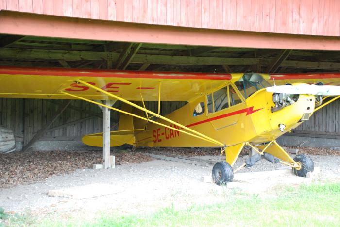 Piper J3C-65 Cub SE-CAN i en hangar på Frölunda. Foto: Bengt Simson.