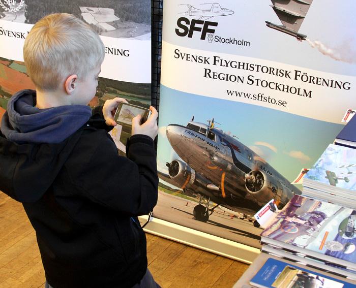 Daisybilden på SFF Stockholms snygga roll-up förevigas av en ung besökare. Foto: Gunnar Åkerberg.