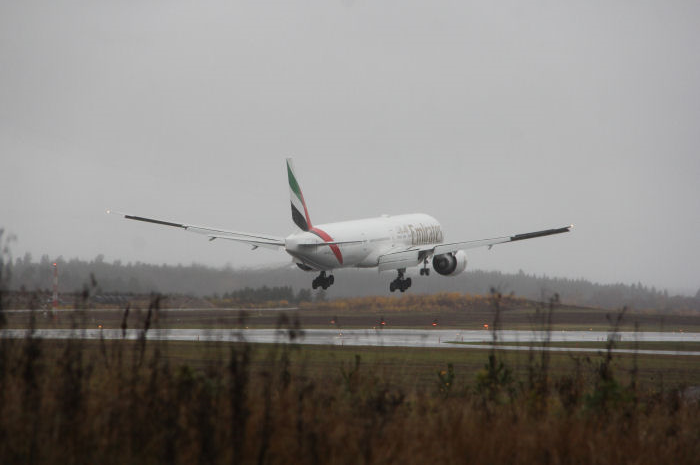 Emirates Boeing 777-300ER sekunderna innan sättning på Arlandas regnvåta bana. Foto: Hans Groby.